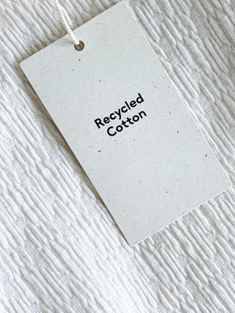 Recycled cotton fashion label tag, sale price card on luxury fabric background, shopping and retail conceptの写真素材