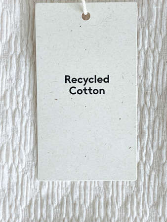 Recycled cotton fashion label tag, sale price card on luxury fabric background, shopping and retail conceptの写真素材