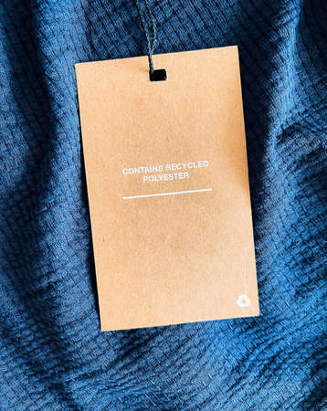 Contains recycled polyester fashion label tag, sale price card on luxury fabric background, shopping and retail conceptの写真素材