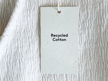 Recycled cotton fashion label tag, sale price card on luxury fabric background, shopping and retail conceptの写真素材
