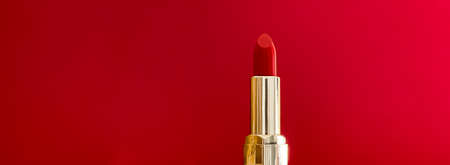 Red lipstick in golden tube on colour background, luxury make-up and cosmetics for beauty brand product design conceptの写真素材