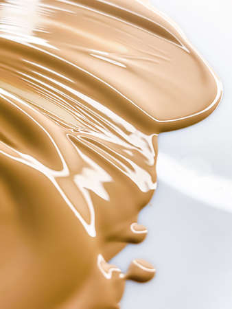 Glossy cosmetic texture, beige liquid foundation or concealer as beauty make-up product background, skincare cosmetics and luxury makeup brand design conceptの写真素材