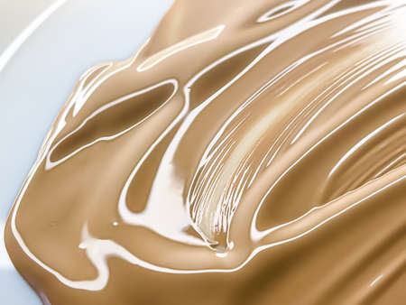 Glossy cosmetic texture, beige liquid foundation or concealer as beauty make-up product background,...