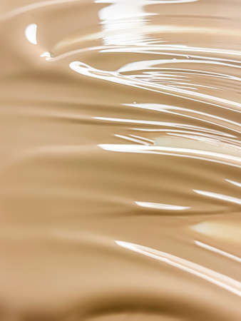 Glossy cosmetic texture, beige liquid foundation or concealer as beauty make-up product background, skincare cosmetics and luxury makeup brand design conceptの写真素材