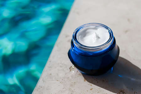 Moisturising beauty cream, skincare and spa cosmetics by swimming pool in summer, cosmetic product...