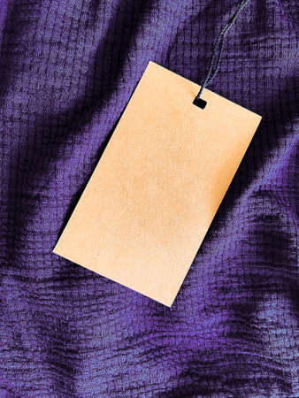 Blank fashion label tag, sale price card on luxury fabric background, shopping and retail concept
