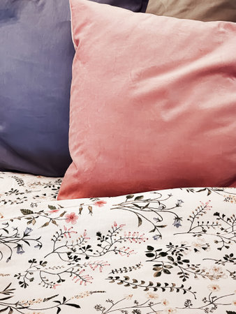Vintage countryside style bedding with floral pattern on wooden bed in bedroom, interior design...