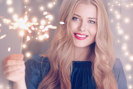 Holiday magic, Christmas and New Year celebration, happy woman with sparklers, portraitの写真素材