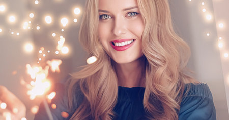 Holiday magic, Christmas and New Year celebration, happy woman with sparklers, portraitの写真素材