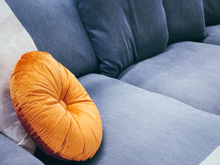 Home decor and interior design, modern blue sofa and orange pillow in living room or office, furniture and decoration detailsの写真素材