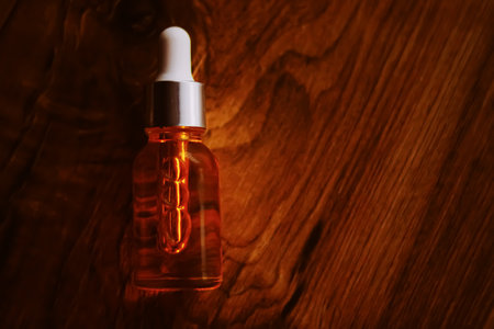 Organic oil serum bottle on natural wooden background with copyspace, beauty and skincare product.の写真素材