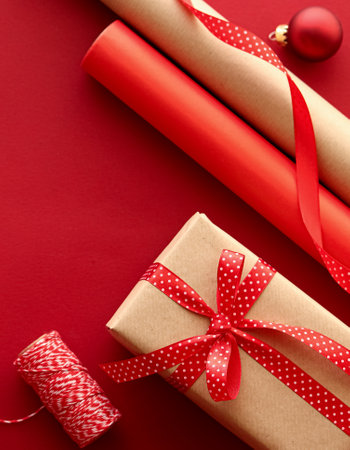 Christmas preparation, boxing day and holidays gift giving, xmas craft paper and ribbons for gifts boxes on red background as wrapping tools and decorations, diy presents as holiday flat lay designの写真素材