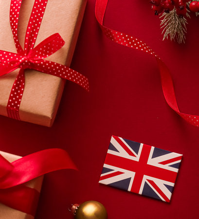 Christmas, boxing day and United Kingdom flag, traditional holiday gifts, presents on red background flat lay, wrapped gift and festive ornaments, decorations as holidays flatlay design.の写真素材