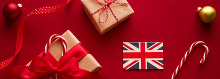 Christmas, boxing day and United Kingdom flag, traditional holiday gifts, presents on red background flat lay, wrapped gift and festive ornaments, decorations as holidays flatlay design.の写真素材