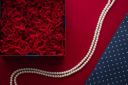 Holiday gift, pearl jewellery necklace and beauty box subscription package mockup for luxury present, empty open gift box flat lay on red background as online shopping delivery, flatlay.の写真素材