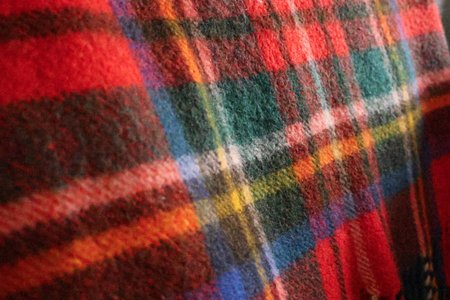 Close up view of a cozy plaid textile, highlighting the rich colors and soft texture of the woven materialの写真素材