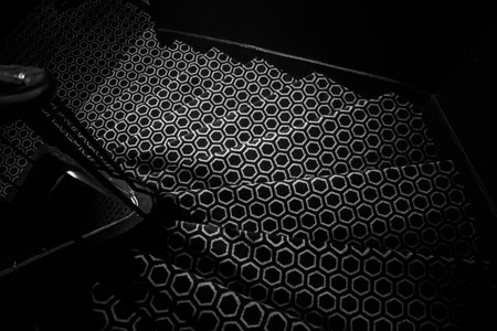 Stairs covered with a patterned carpet showing repeating hexagonal shapes in black and white,...