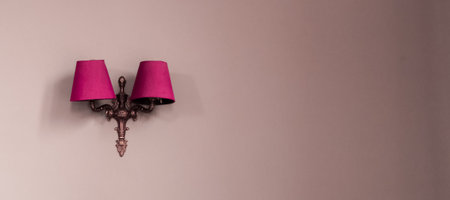 Wall sconce with pink lampshades providing stylish lighting and decoration against a minimalist background, offering extensive copy spaceの写真素材