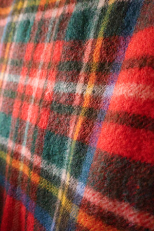 Close up view of traditional plaid wool fabric. Soft and warm texture with red, green, blue, yellow, and white color patternの写真素材