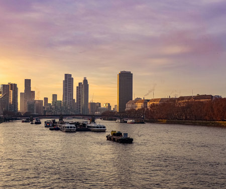 London skyline framing the Thames river with boats at sunset, vibrant orange and purple colors...