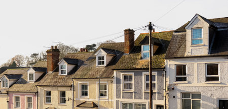 Row of traditional houses with pitched roofs and dormers, portraying a typical residential street in...