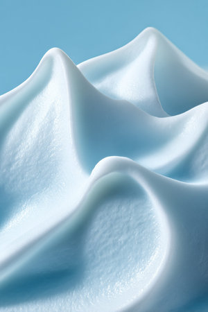 Swirling light blue cosmetic cream showing a wavy texture with soft peaks, representing freshness,...