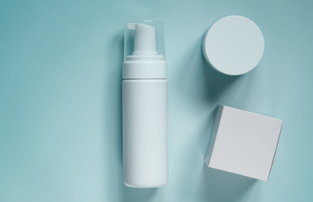 Skincare product packaging layout featuring a white pump dispenser, moisturizer jar, and blank box...