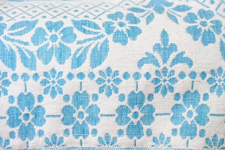 Detail of a vintage woven wool fabric, blue flowers on white background