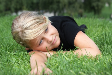 A young girl relaxing on green grassの写真素材