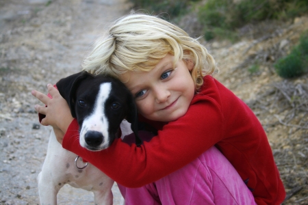 A young girl hugging a puppyの写真素材