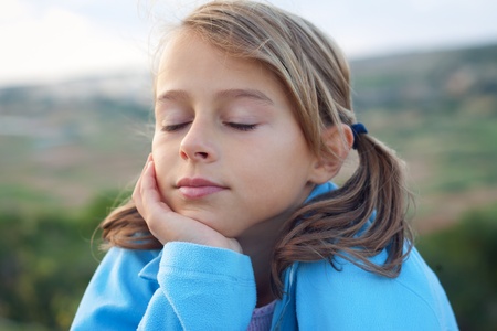 Smiling young girl with closed eyesの写真素材