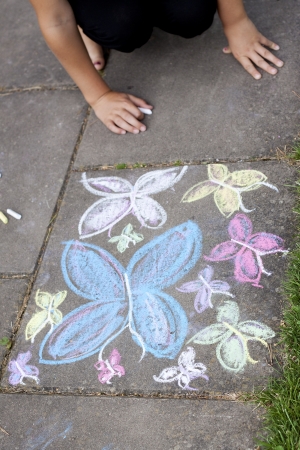 Pavement with a butterfly chalkdrawing and hands of a childのeditorial素材