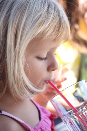 Profile portrait of young child drinking with a strawの写真素材