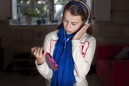 A girl holding an ebook wearing headphonesの写真素材