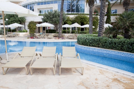 Detail of a curved pool surrounded by trees and sunbedsのeditorial素材