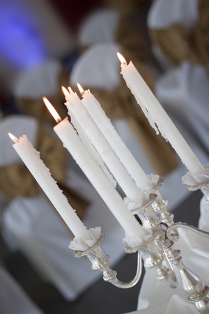 Close up of a silver candelabra with lit candles, shot in a tilted angleの写真素材