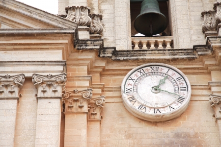 Close up of a church clock and church bell on a Maltese churchの写真素材