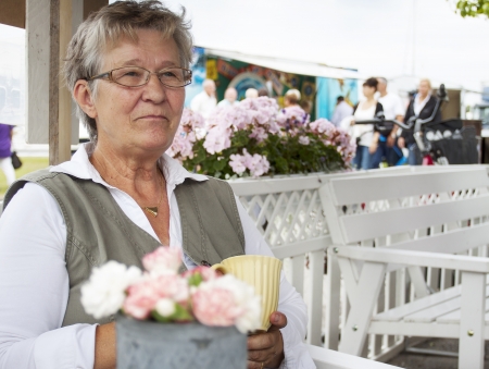 Retired pensioner woman sitting in an outdoor cafeの写真素材