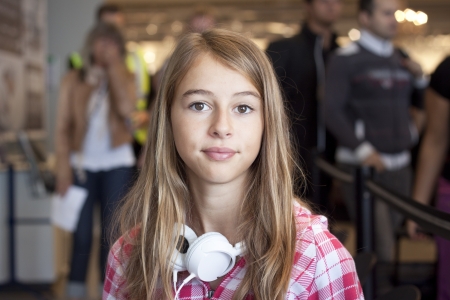 A young woman sitting in an airport lounge, waiting to board a planeの写真素材