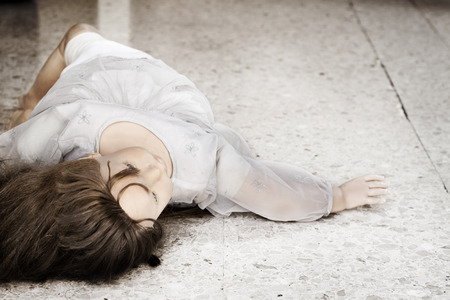 An old doll thrown away staring up in the airの写真素材