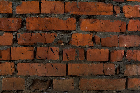 Old brickwork closeup. Red cracked bricks. Weathered cement. The rectangular background.