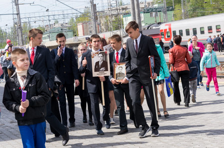 SARATOV, RUSSIA - MAY 6, 2017: Teenagers with portraits of veterans at the railway station. Immortal regiment. People meet mobile Museum "Train of Victory" is dedicated to Great Patriotic War.のeditorial素材