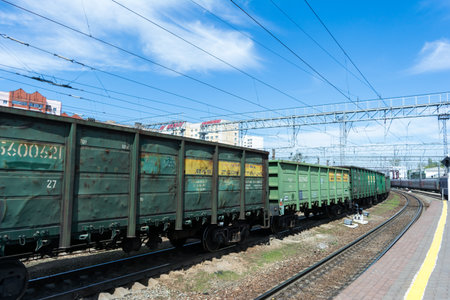 SARATOV, RUSSIA - MAY 6, 2017: Freight train at the railway station. Old rusty metal cars are painted with green paint.のeditorial素材