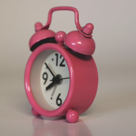 Retro Pink Miniature Alarm Clock on White Background - Sideの写真素材