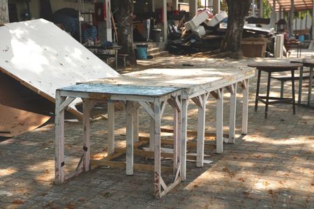 Vintage Rustic Wooden Tables/ Chairs/ Stools Painted in Teal/ White Colors in Outdoor Garage/ Abandoned Studio Backyard/ JunkYard - Under the Tree in a Sunny Dayの写真素材