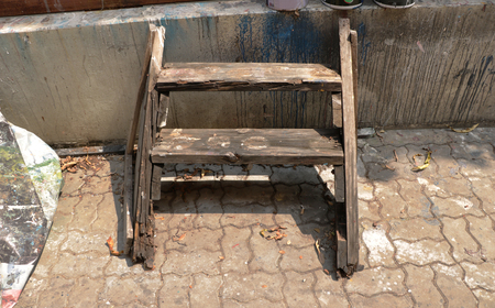 Vintage Old Wooden Plant Rack/ Shelf/ Ladder/ Stool Chair with Dirty Wall Background - Outdoor Garage/ Abandoned Junkyard/ Home Garageの写真素材