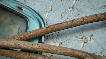 Abandoned Car Window Frame with Logs on Rough Painted Teal Wall - Garden/ Junkyard. Rural Thailand.の写真素材