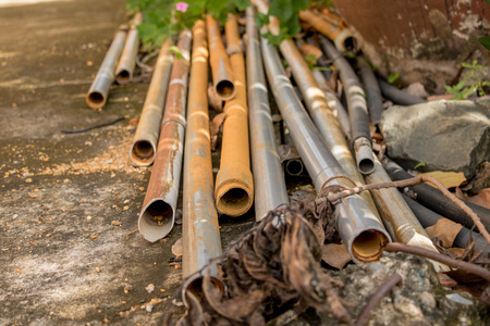 Vintage Old PVC Water Pipes on Concrete Ground - Outdoor Garden/ Dry Tree Branchの写真素材