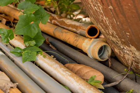 Vintage Old PVC Water Pipes on Concrete Ground - Outdoor Gardenの写真素材