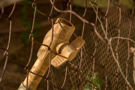 Close-up Dirty PVC Valve/ Plastic Pipe - Rusty Old Wire Fence - Abandoned Junkの写真素材